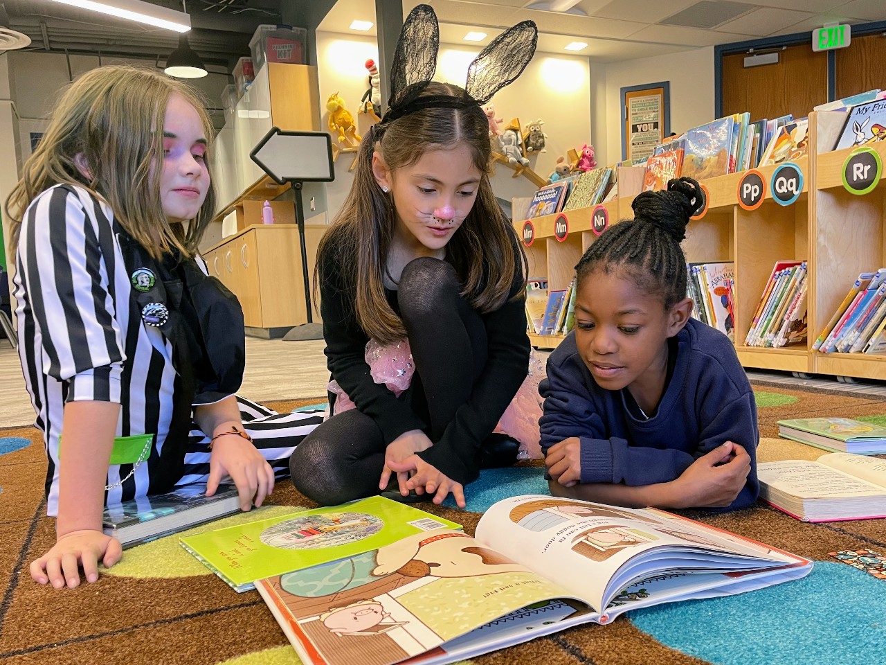 Three HPES students study the same book in the library.